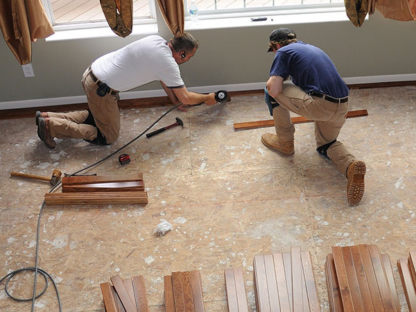 Two Ascension General Contractors installing wood floors
