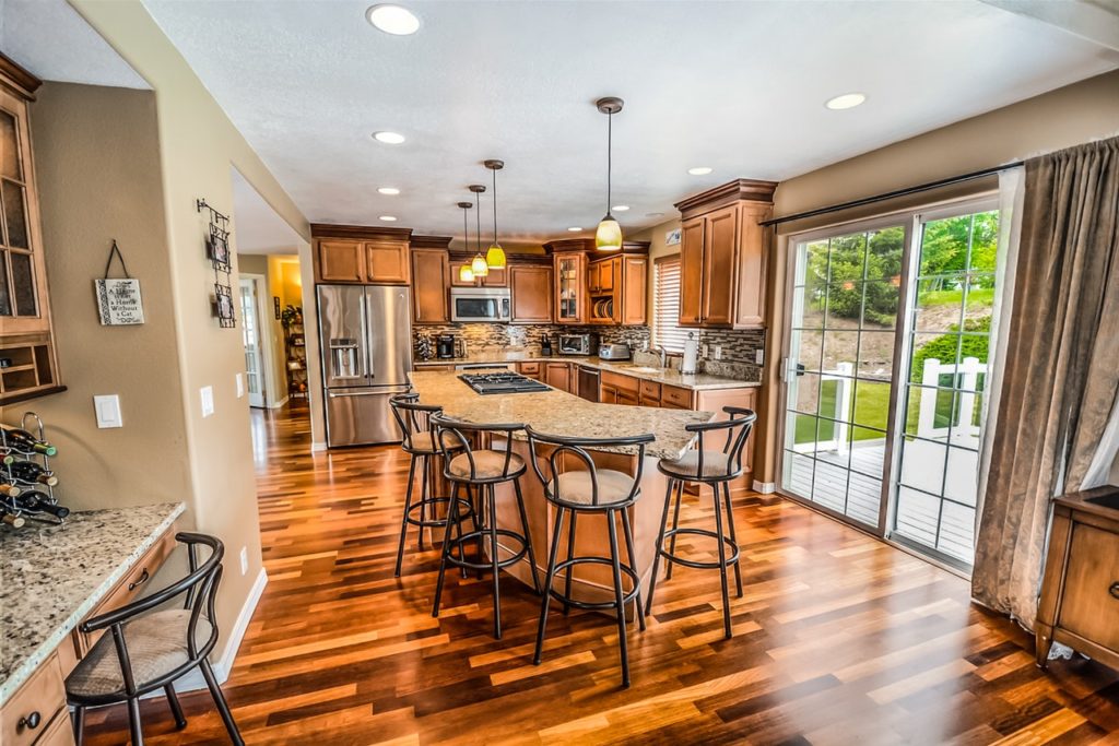 Renovated kitchen with bar stool seating area, dark wood, and stainless steel appliances