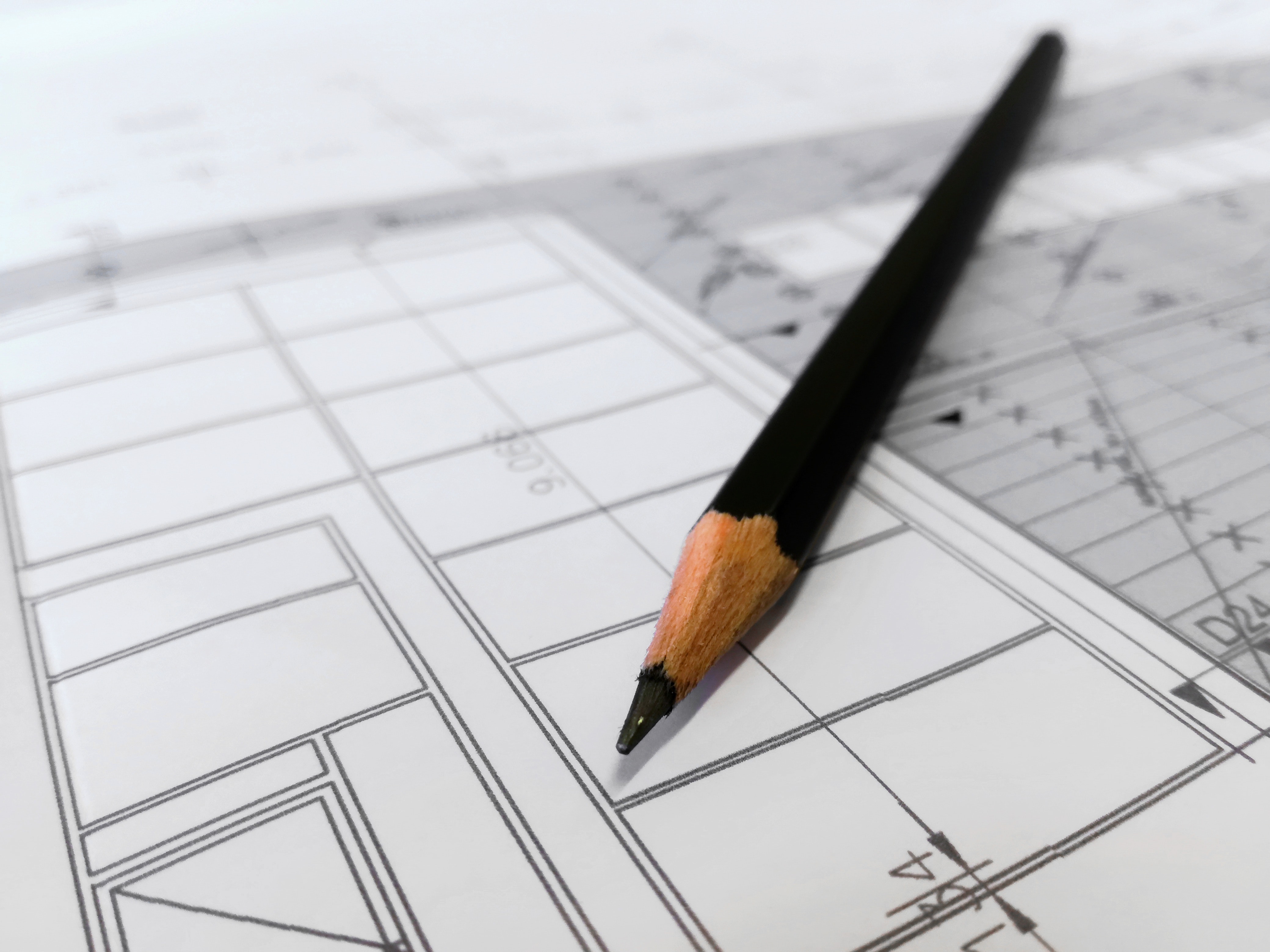 close-up view of a sharpened pencil laying on architecture plans