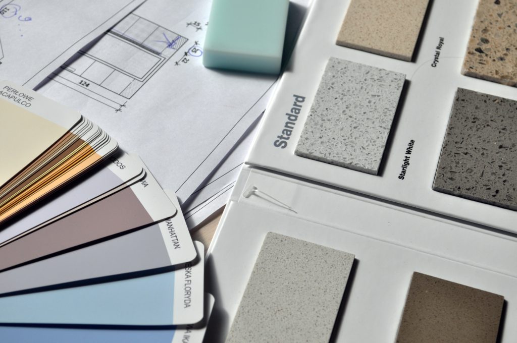 Paint and counter material samples over home renovation plans