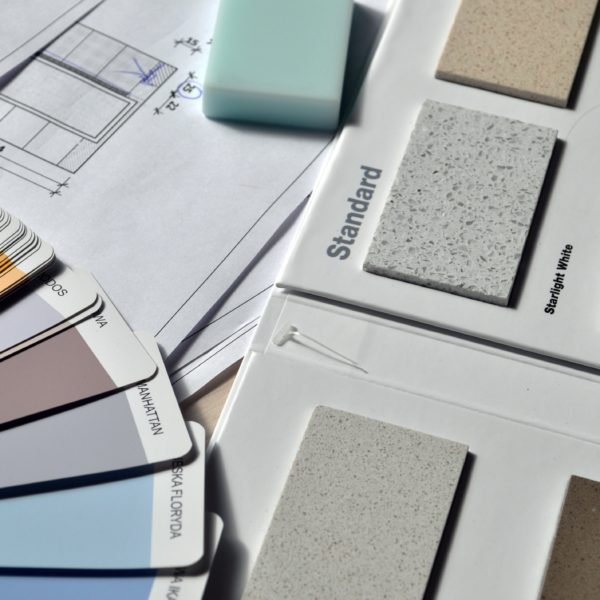 Paint and counter material samples over home renovation plans