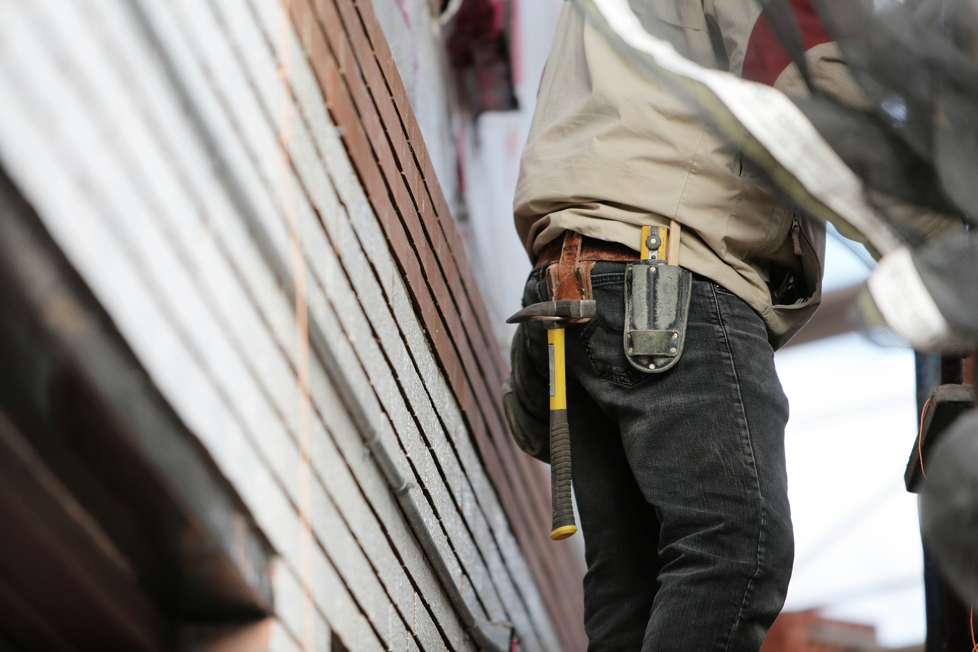 Close-up view of construction worker's tool belt as he works outside