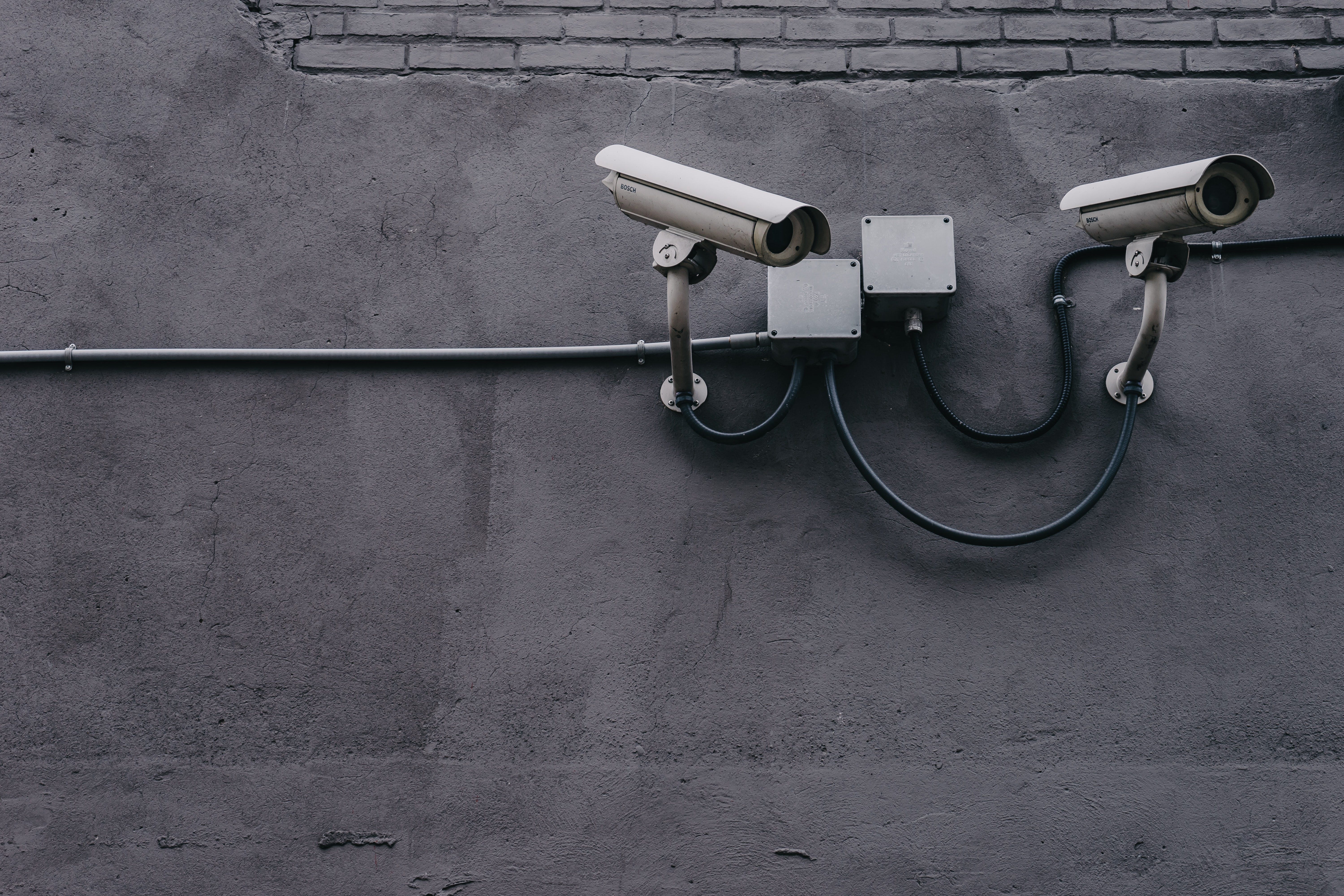 Cropped view of a security camera mounted on exterior of commercial building