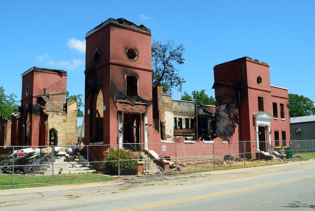 Cropped view of burned out red brick building