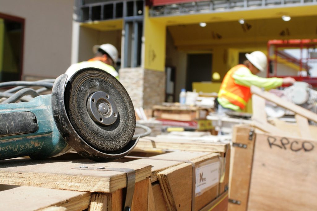 Working construction site, close up of tools with workers faded in background