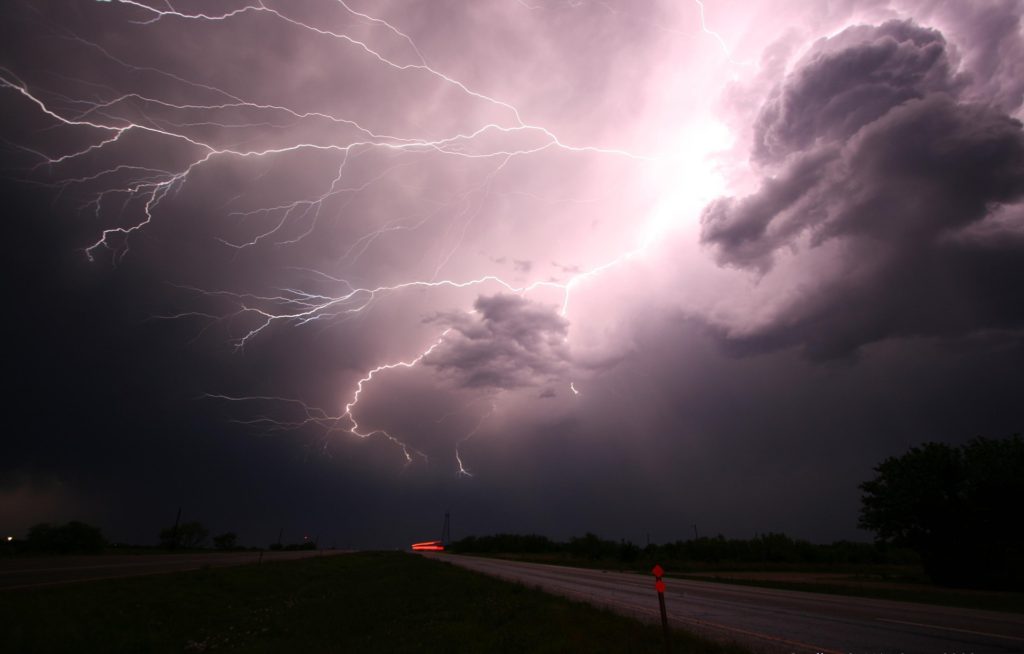 Open road with lightning storm above