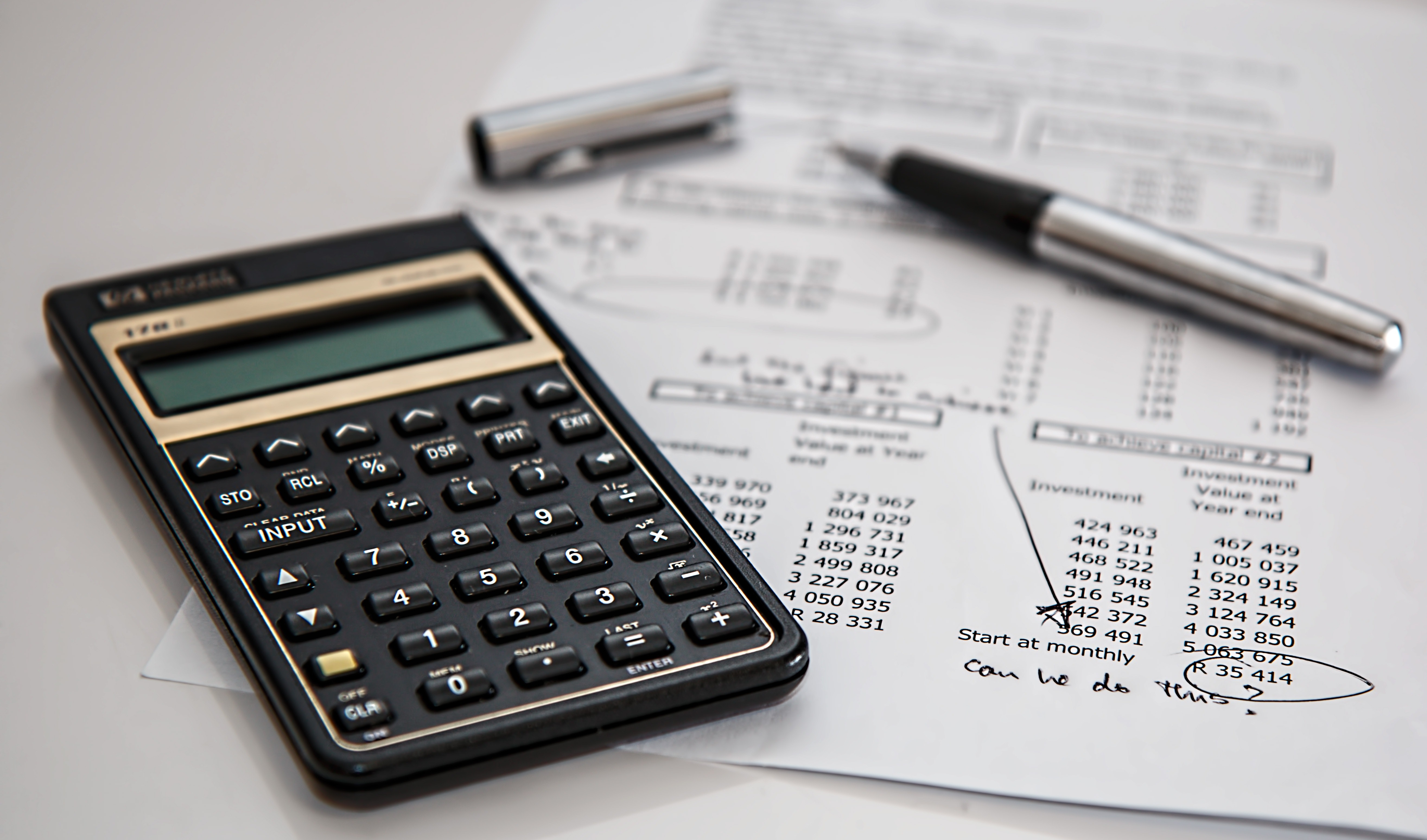 calculator, silver pen, and budget sheet for commercial renovation project