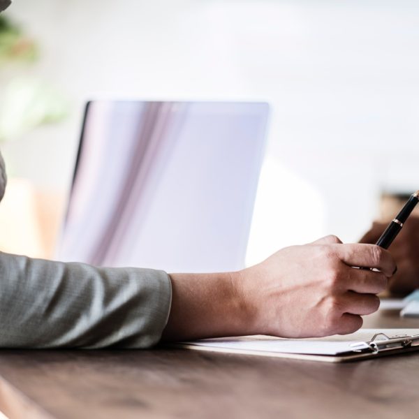 person at table holding pen and looking through papers with contractor