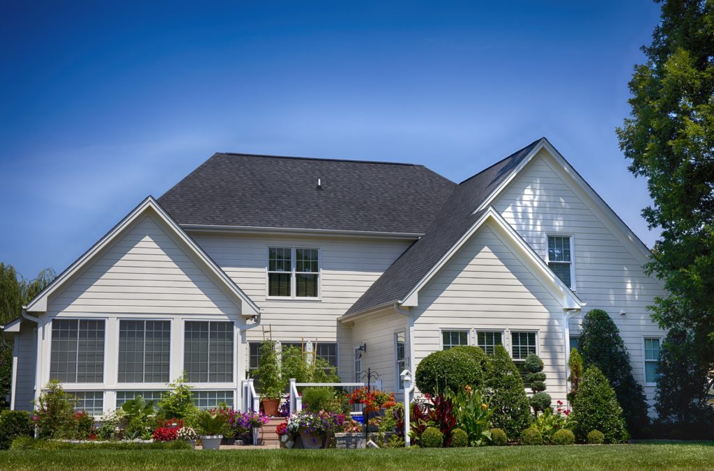 white suburban home with lush lawn and landscaping