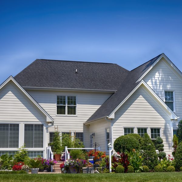 white suburban home with lush lawn and landscaping