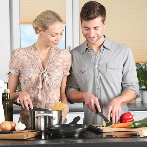 happy couple cooking dinner in kitchen together
