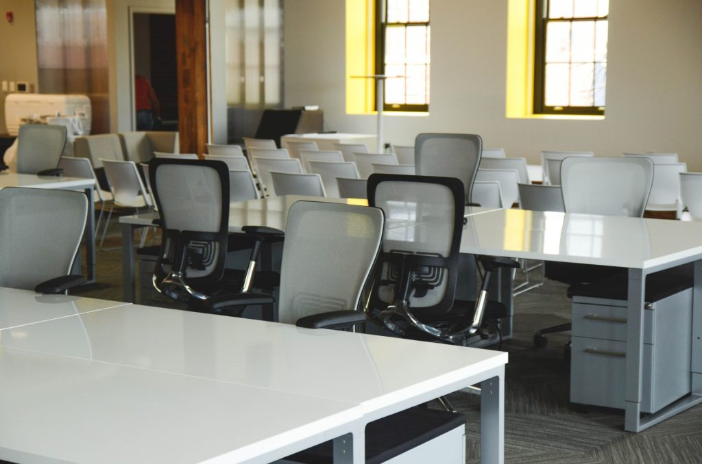 modern conference room with white tables and gray rolling chairs