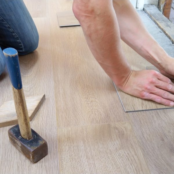 handyman installing faux wood flooring