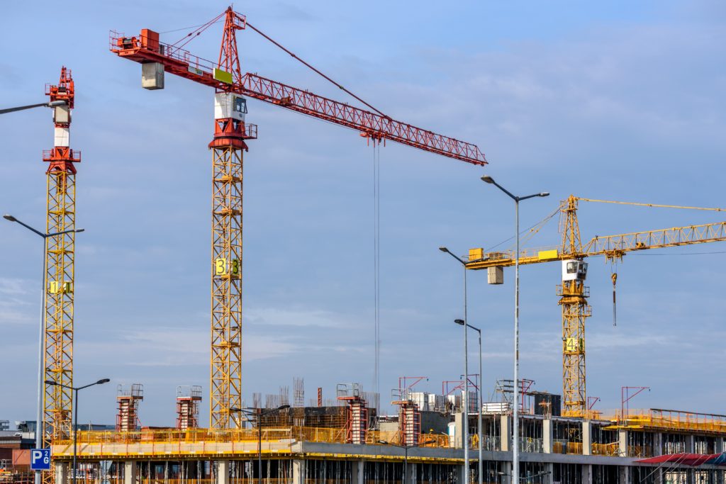 two cranes and new building being constructed