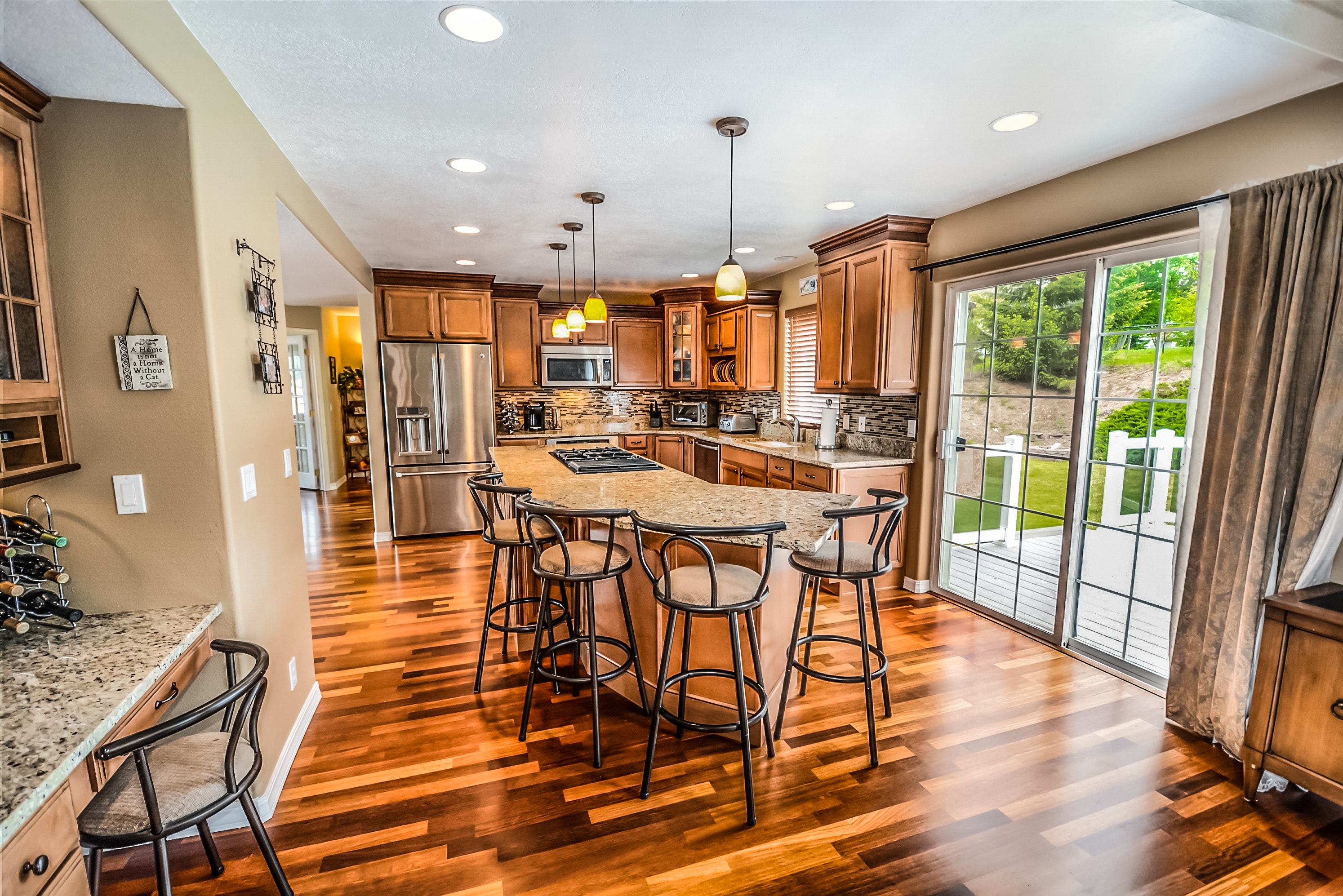 renovated kitchen with bar seating, bright lights, and brown natural color scheme