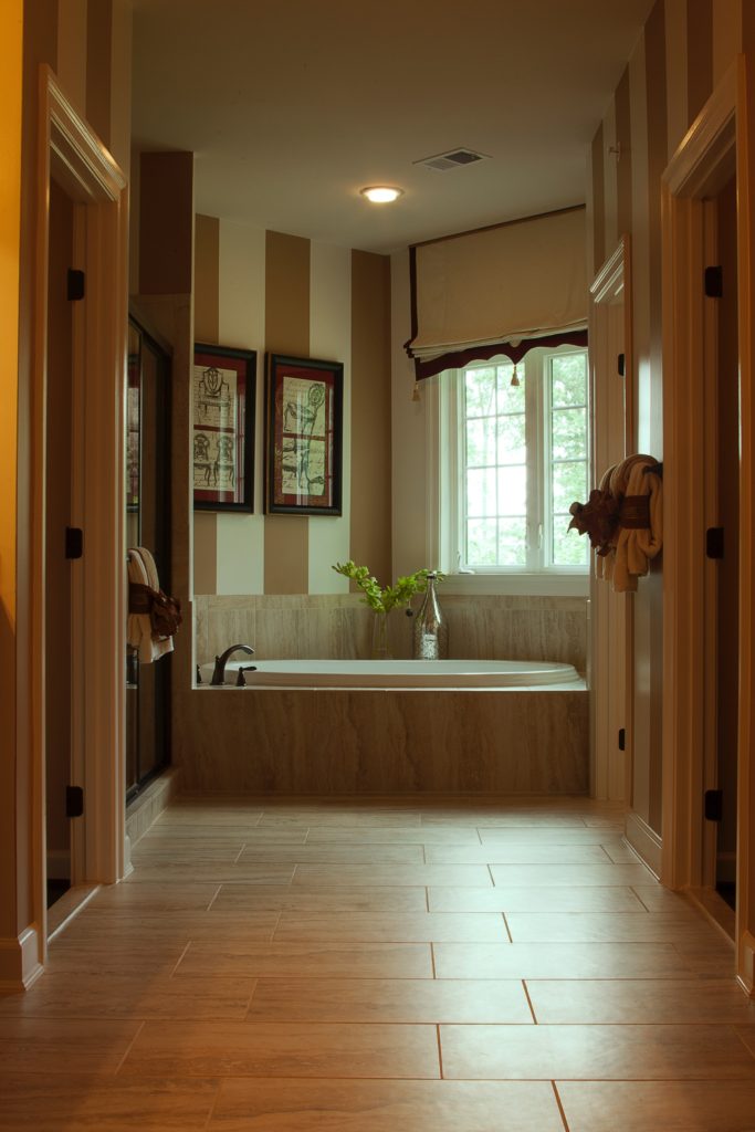 beautiful master bathroom with soaker tub and his and hers closet