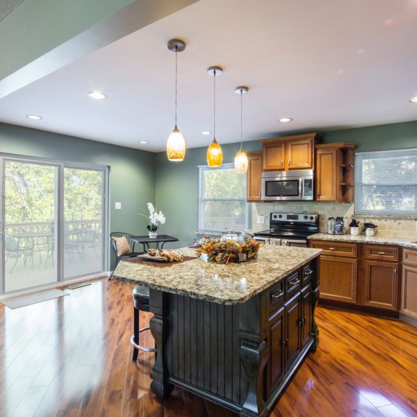 light green kitchen with center island and wood floors