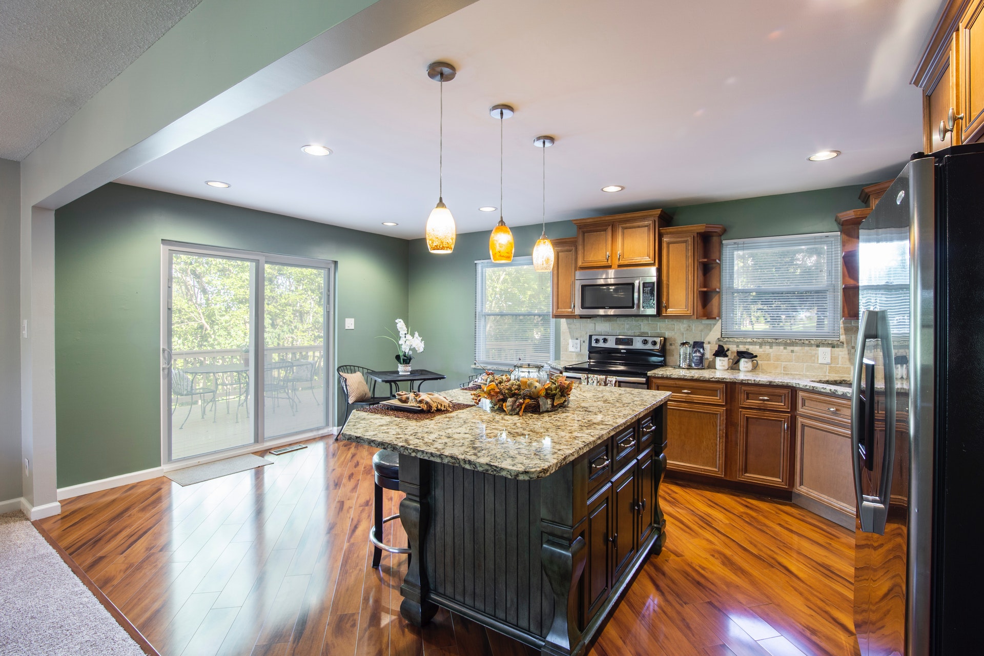 light green kitchen with center island and wood floors