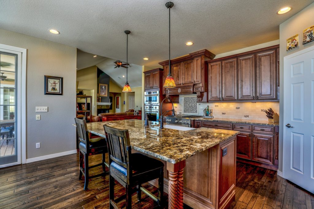 remodeled dark wood kitchen with center island and bar chairs