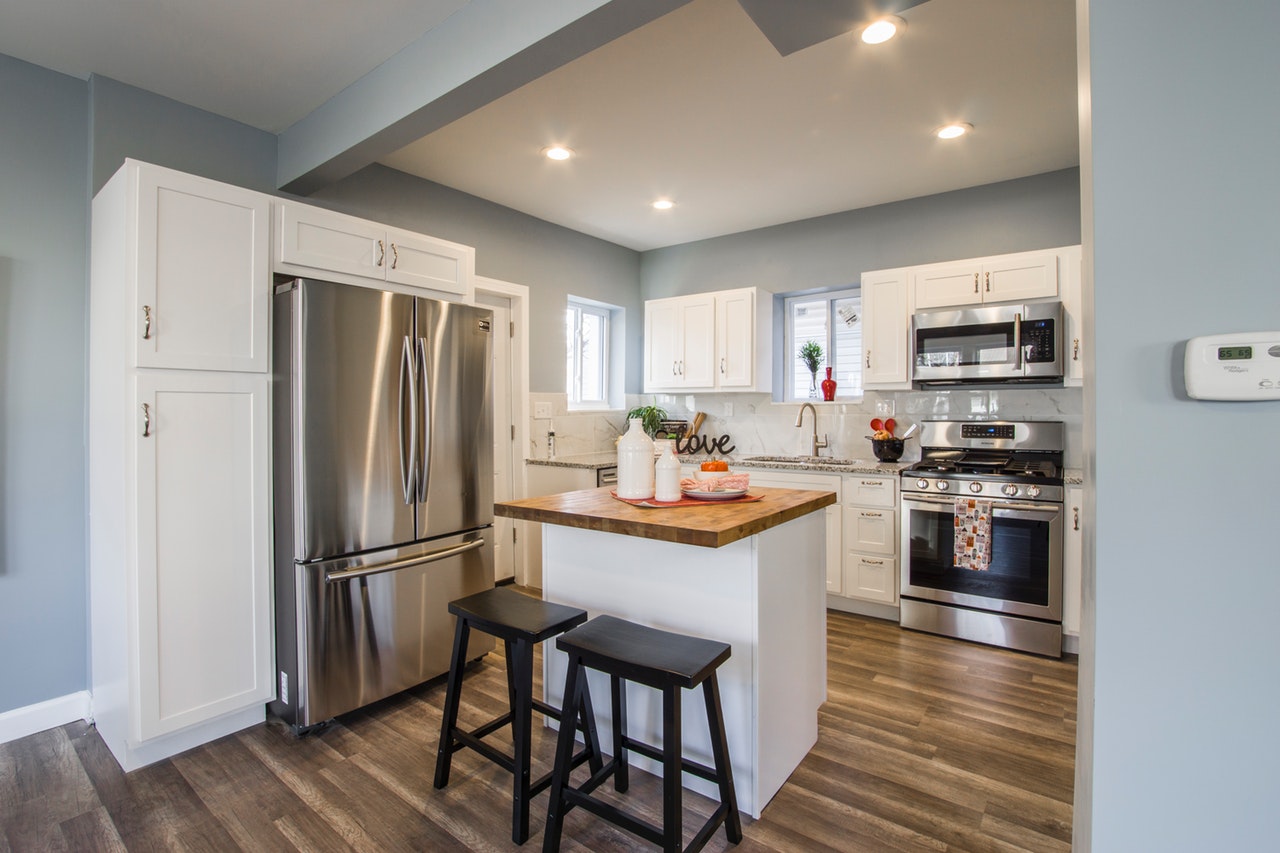 modern blue gray kitchen with white cabinets and two bar stool island