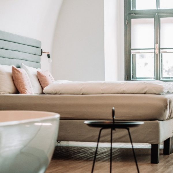 a bed with white and pink pillows and a thick comforter