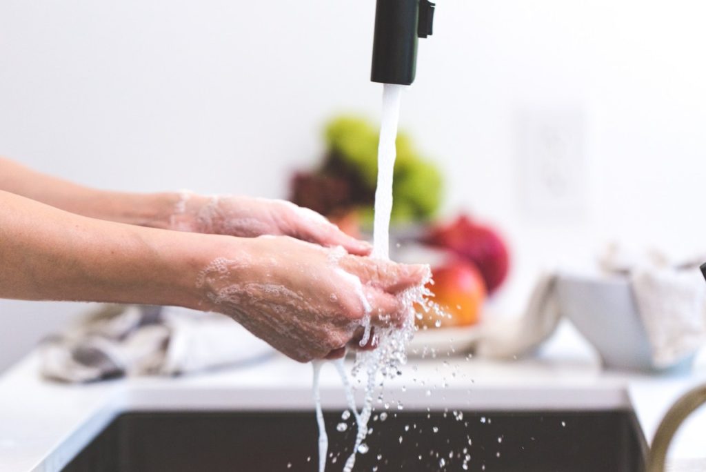 A woman washing her hands in a modern sink