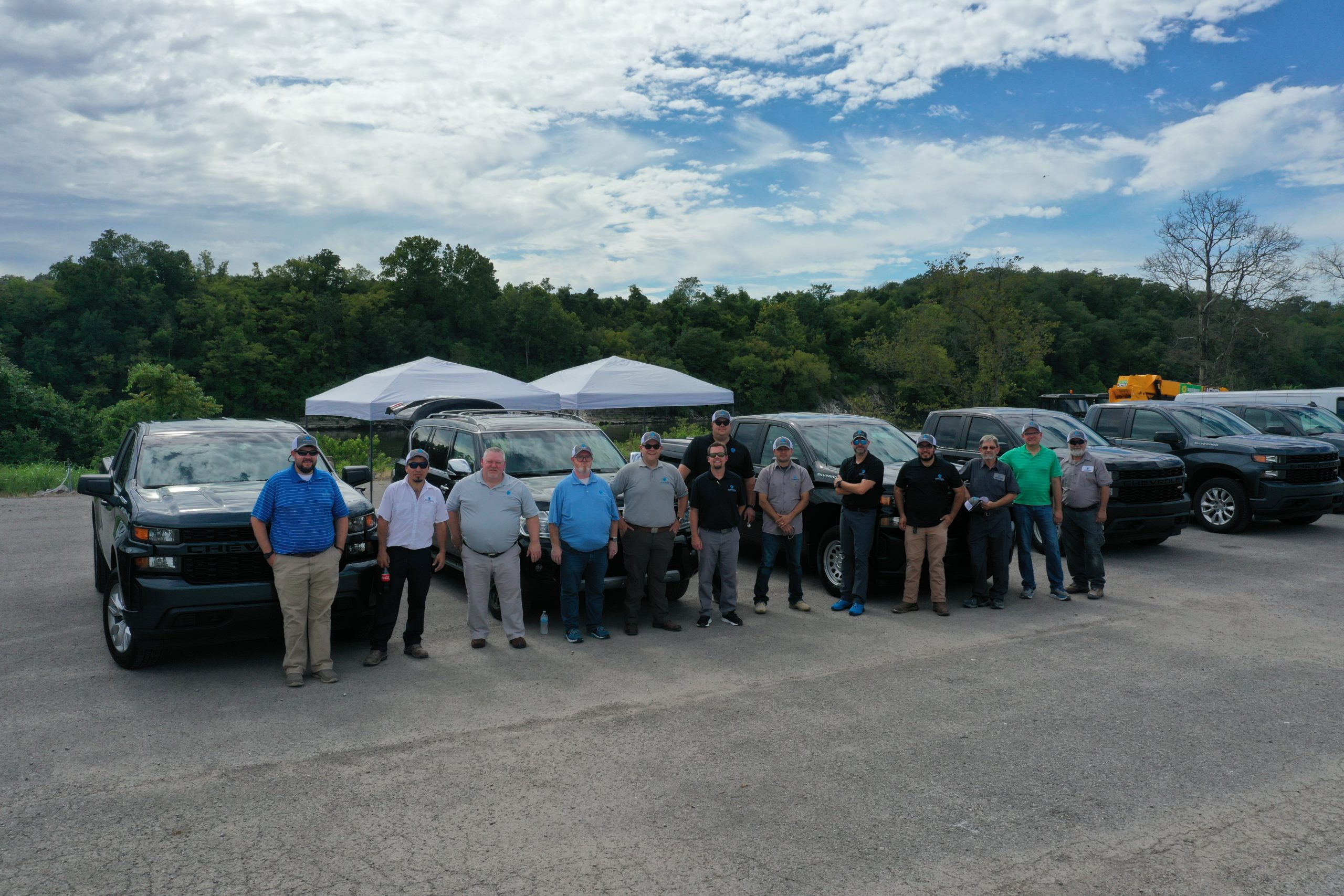 Ascension General Contractors company standing in front of a line of vehicles