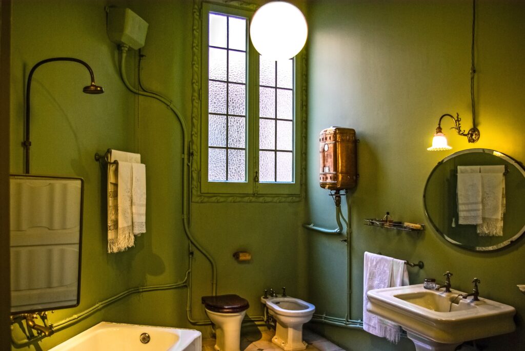 Green-walled bathroom with toilet and two sinks